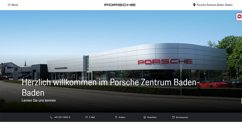 Außenansicht des Porsche Zentrums Baden-Baden mit moderner Glas- und Metallfassade, Porsche-Logo und einem roten Sportwagen im Vordergrund - ein Screenshot der Website www.porsche-baden-baden.de